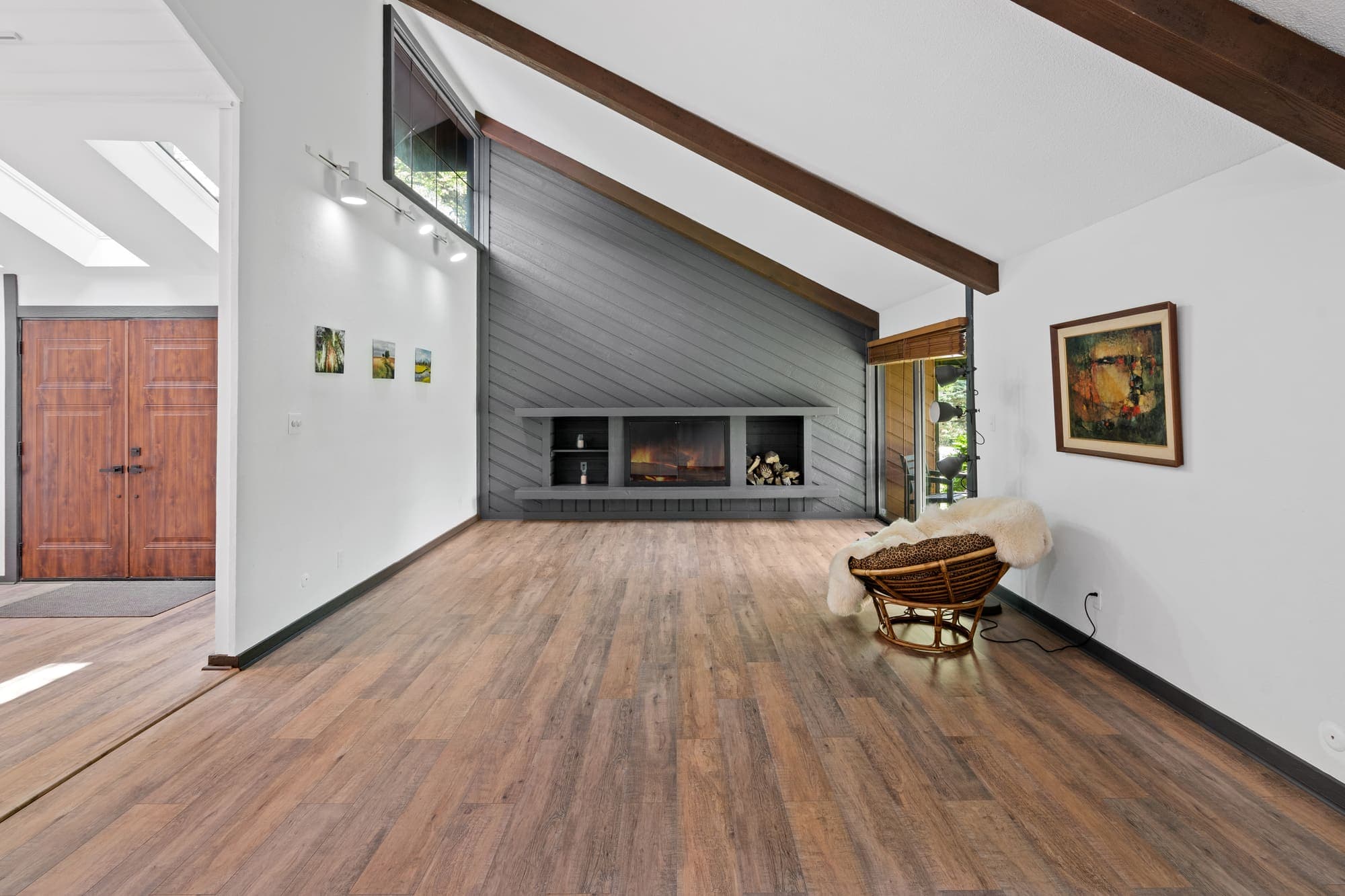 Contemporary living room with exposed beams and wide-plank floors