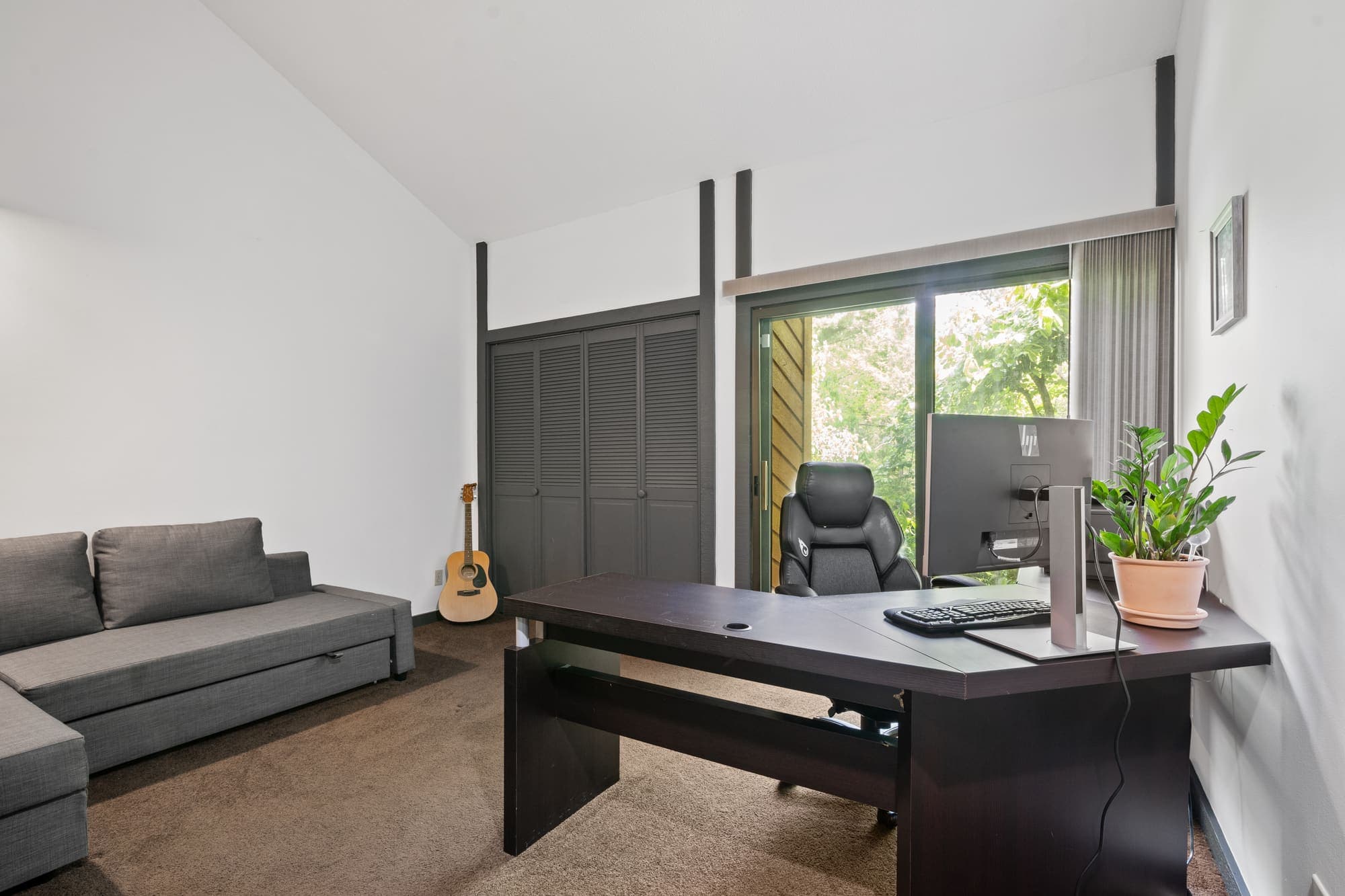 Office with black built-in desk and garden window