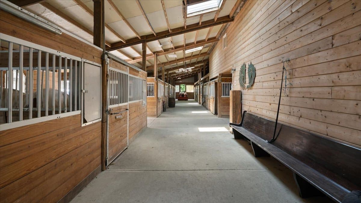 Horse barn interior with stalls and a long center aisle